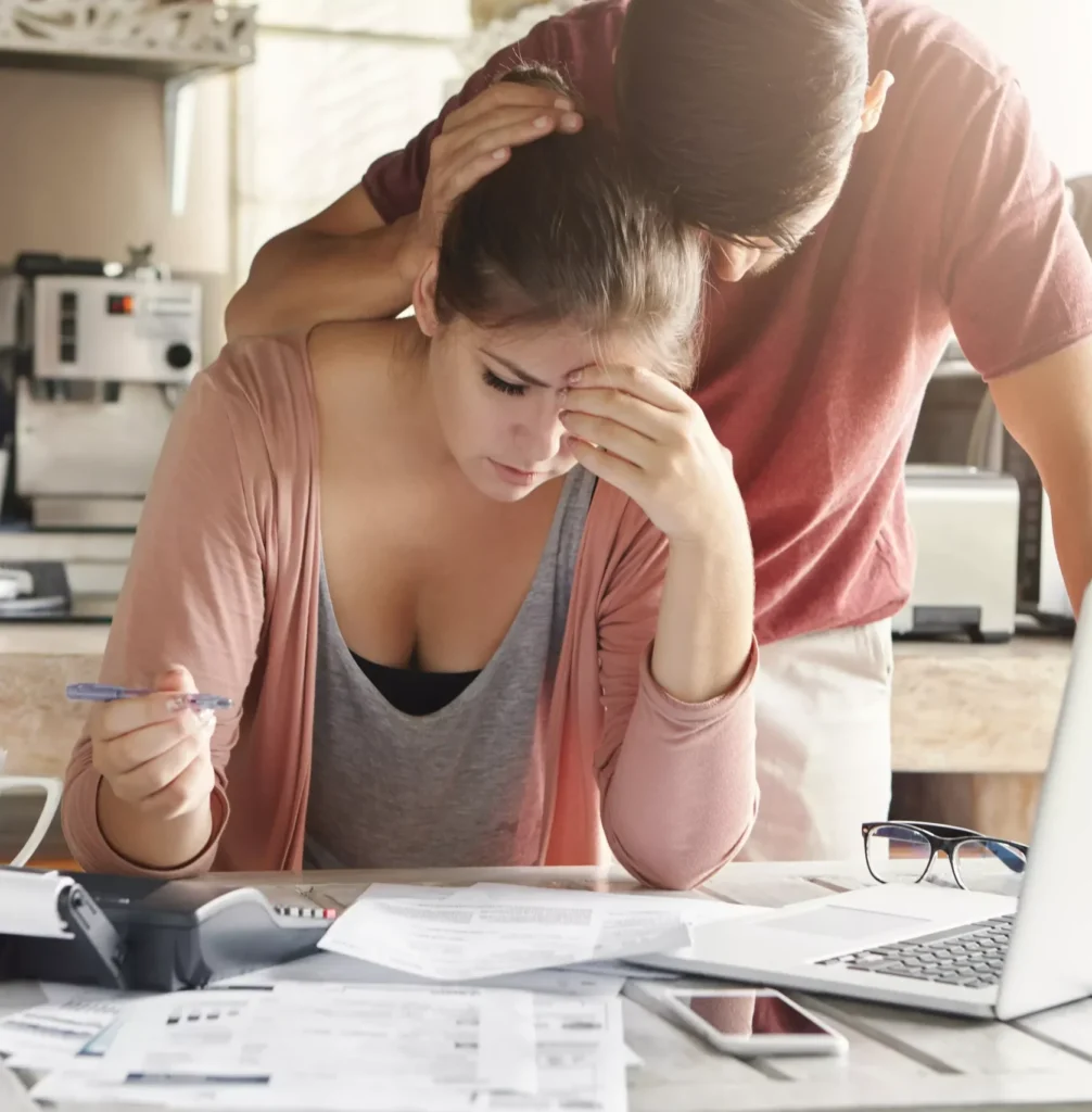 anyconv.com unhappy couple unable pay loan time stressed female doing paperwork sitting table with laptop papers calculator cell phone man trying support his wife e1770817904545.webp